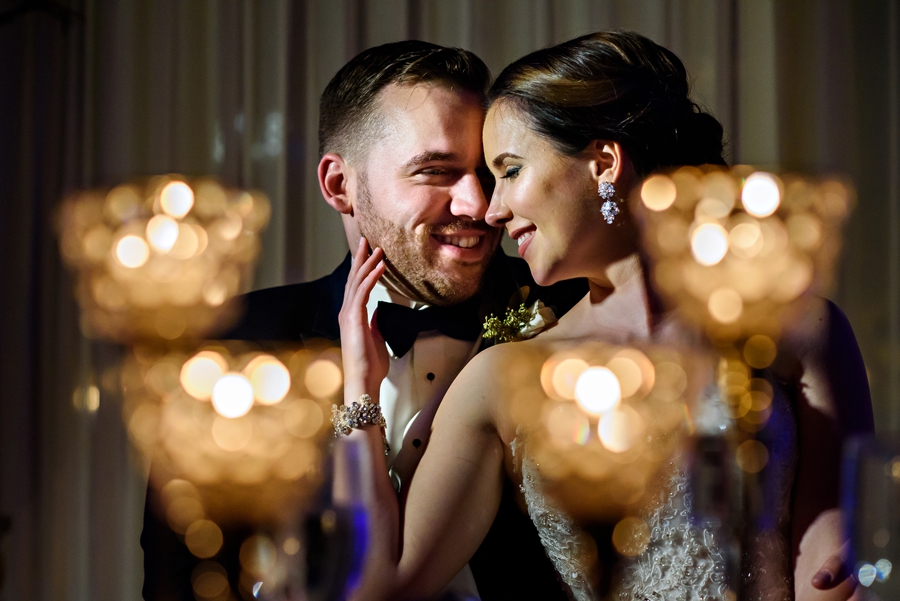 A married couple holding each other at thier sweetheart table during the wedding reception.